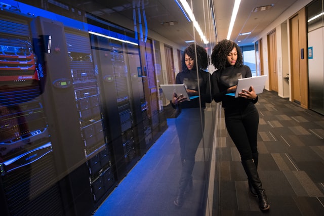 Engineer with laptop beside a server room