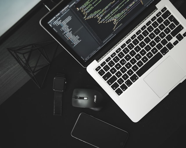 Laptop with code on a dark desk